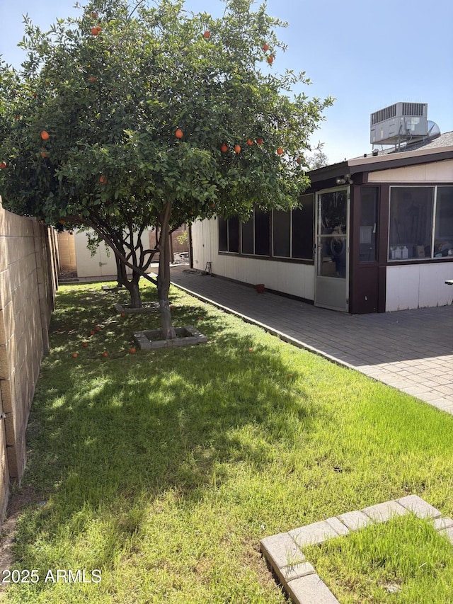 view of yard featuring central AC unit, a sunroom, and a deck