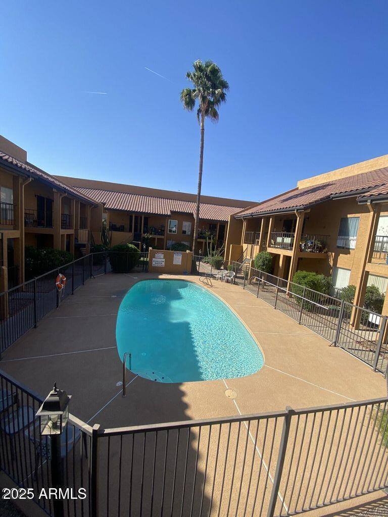 community pool with fence and a patio