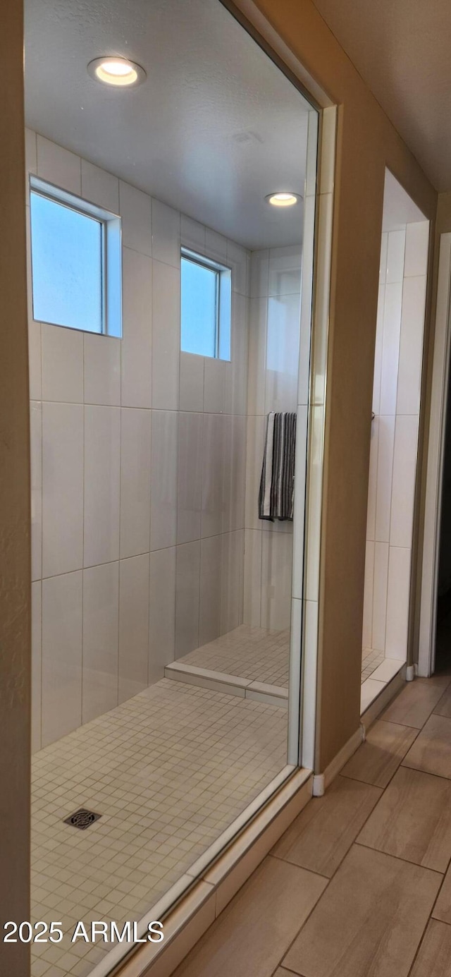 bathroom with a healthy amount of sunlight and tiled shower