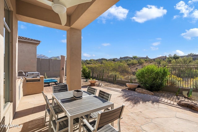 view of patio featuring ceiling fan, grilling area, and a mountain view