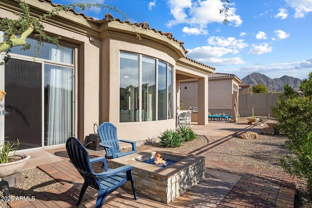 view of patio with a mountain view and a fire pit