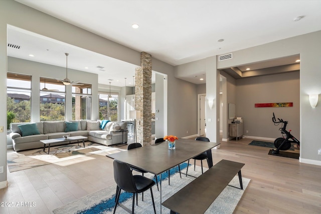 dining space featuring ceiling fan, light hardwood / wood-style flooring, and ornate columns