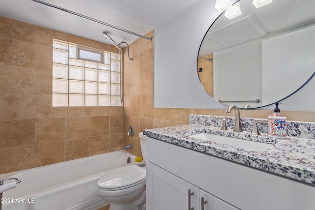 full bathroom featuring tiled shower / bath, vanity, and toilet