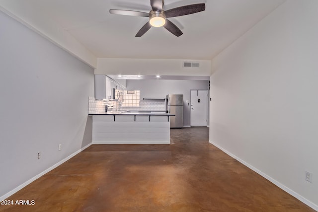 kitchen featuring backsplash, kitchen peninsula, stainless steel fridge, ceiling fan, and white cabinets