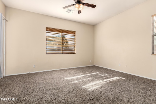 spare room with ceiling fan, carpet, and baseboards
