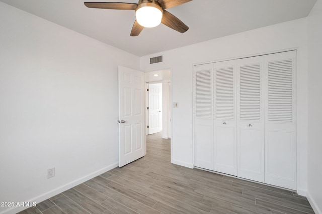 unfurnished bedroom with ceiling fan, a closet, and light hardwood / wood-style flooring