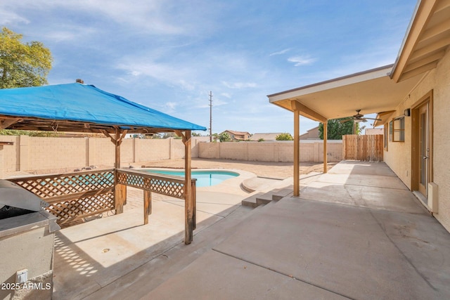 view of swimming pool with ceiling fan and a patio area