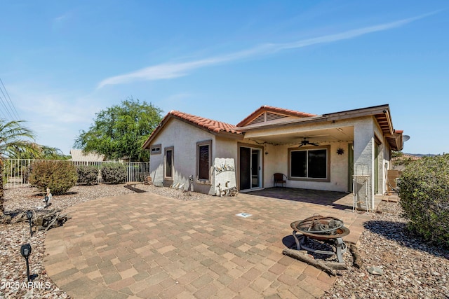 23075 W Arrow Dr, Buckeye, AZ 85326 - rear view of house with a ceiling fan, an outdoor fire pit, stucco siding, a fenced backyard, and a patio