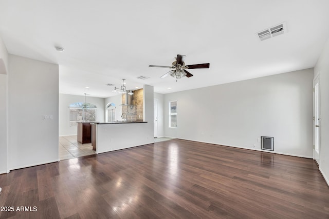 23075 W Arrow Dr, Buckeye, AZ 85326 - unfurnished living room with a ceiling fan, wood finished floors, and a chandelier