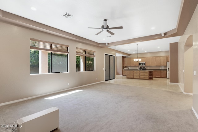 unfurnished living room featuring light carpet and ceiling fan with notable chandelier