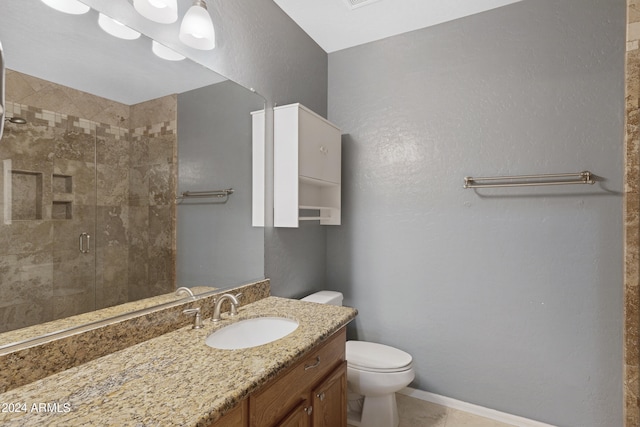 bathroom with toilet, vanity, an enclosed shower, and tile patterned flooring