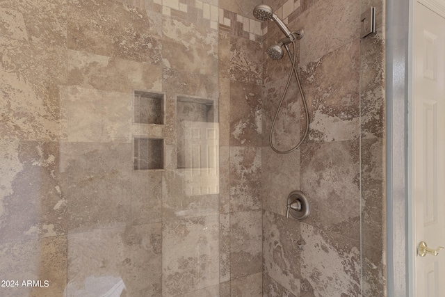 interior details featuring a tile shower