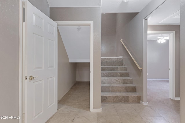 stairs featuring ceiling fan