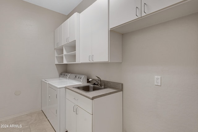 washroom with washer and dryer, sink, and cabinets