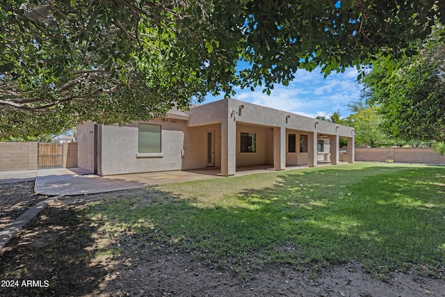 rear view of house featuring a yard and a patio