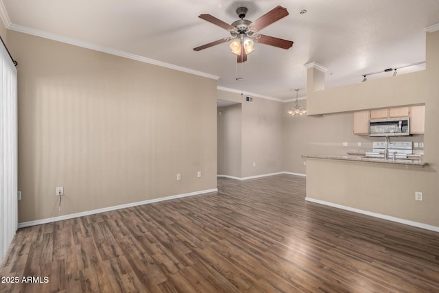 unfurnished living room with dark wood-type flooring, crown molding, baseboards, and ceiling fan with notable chandelier