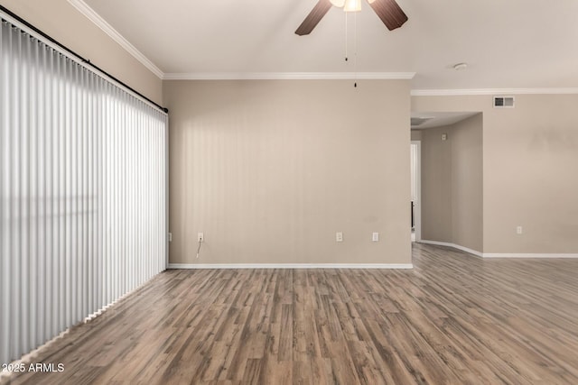 spare room featuring visible vents, crown molding, baseboards, and wood finished floors