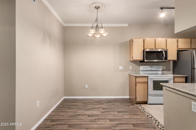 kitchen with light brown cabinets, baseboards, light countertops, appliances with stainless steel finishes, and crown molding