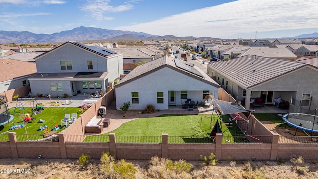 rear view of property featuring a patio area, a fenced backyard, a residential view, and a mountain view