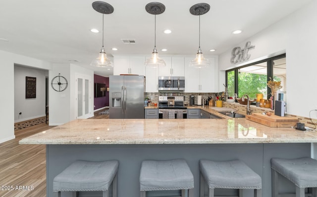 7806 N Via Del Sol, Scottsdale, AZ 85258 - kitchen featuring appliances with stainless steel finishes, light stone counters, a peninsula, decorative backsplash, and recessed lighting