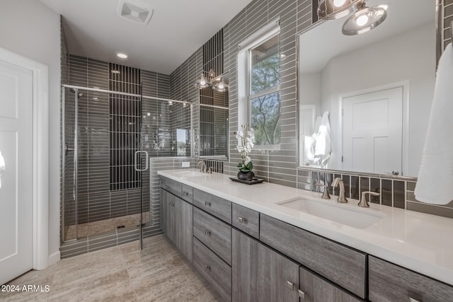 bathroom featuring backsplash, vanity, a shower with shower door, and tile patterned flooring