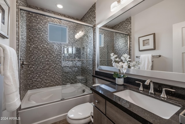 full bathroom featuring shower / bath combination with glass door, vanity, and toilet