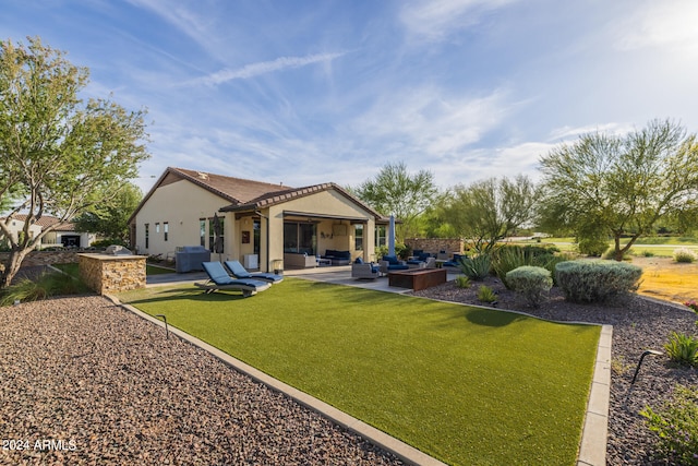 rear view of house with a lawn, a patio, and an outdoor hangout area