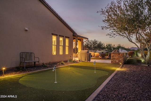 yard at dusk featuring a patio