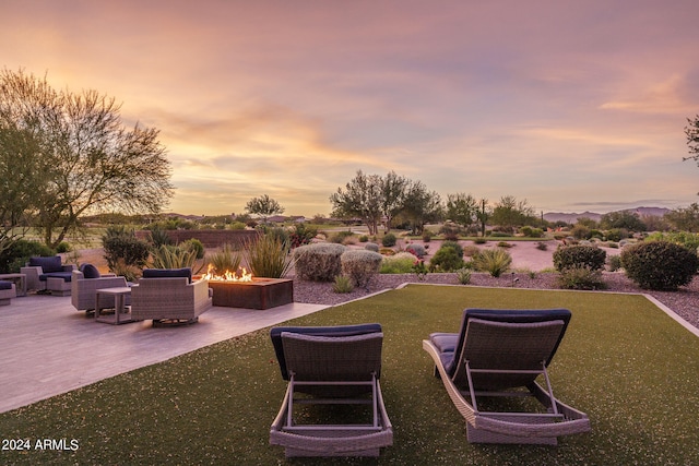 yard at dusk with a patio and a fire pit