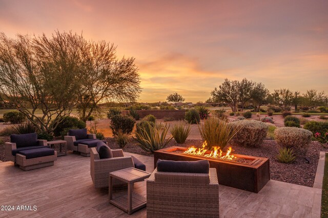 patio terrace at dusk with an outdoor living space with a fire pit