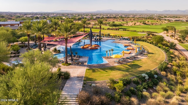 view of pool with a mountain view and a yard