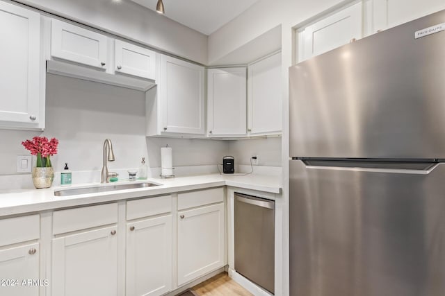 kitchen with sink, stainless steel appliances, and white cabinets