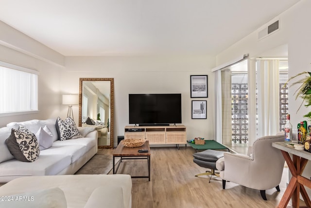 living room with a wealth of natural light and light hardwood / wood-style flooring