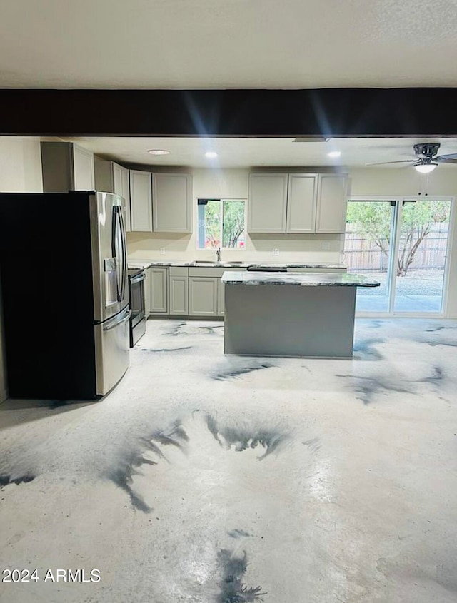 kitchen with appliances with stainless steel finishes, a wealth of natural light, gray cabinetry, and ceiling fan