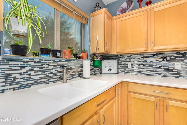 kitchen with light brown cabinets, tasteful backsplash, and sink