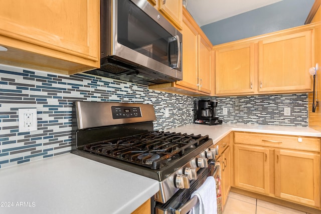 kitchen featuring decorative backsplash, stainless steel appliances, light brown cabinets, and light tile patterned flooring