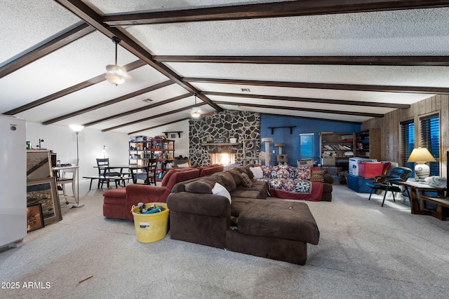 living room with light carpet, vaulted ceiling with beams, a stone fireplace, and a textured ceiling