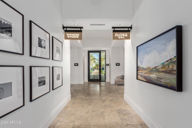 corridor featuring light tile floors and french doors