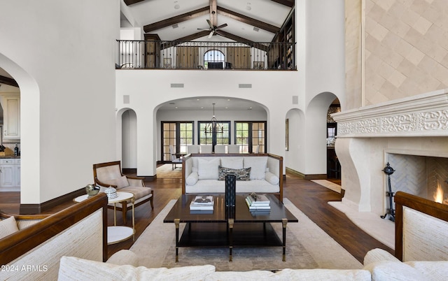 living area with visible vents, baseboards, ceiling fan, beamed ceiling, and wood finished floors