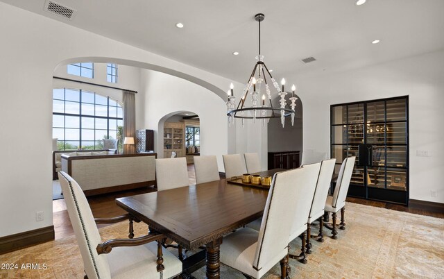 dining area with arched walkways, visible vents, and recessed lighting