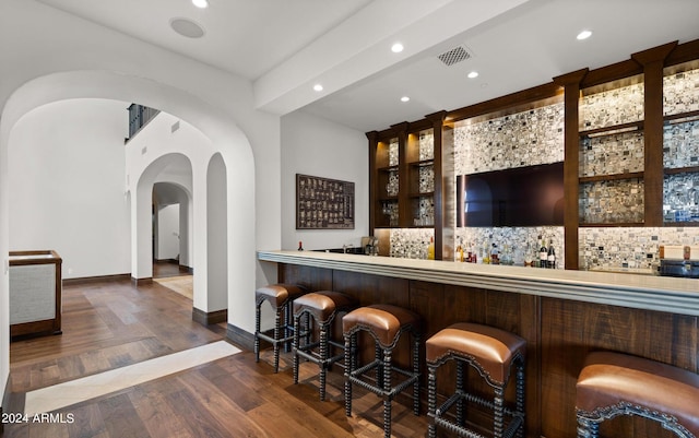 bar featuring arched walkways, visible vents, wood finished floors, indoor wet bar, and recessed lighting