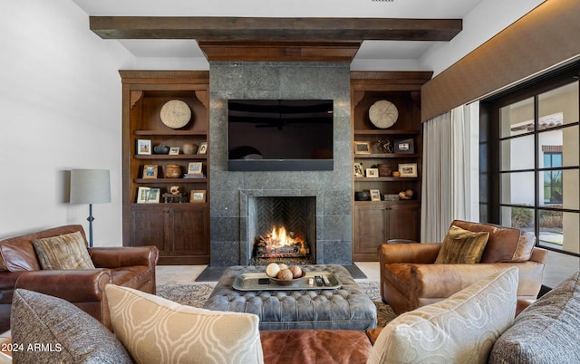 living room featuring built in features, beamed ceiling, and a tile fireplace