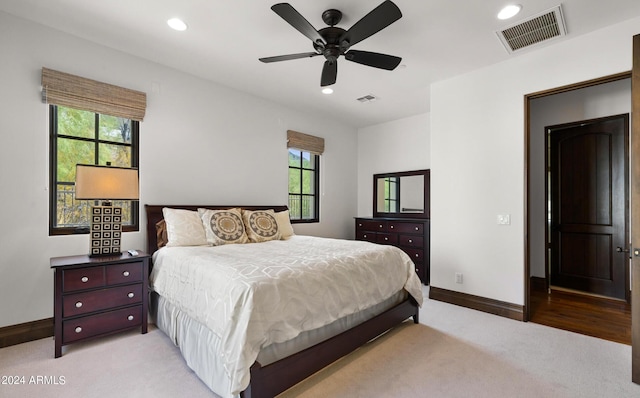 bedroom with light carpet, visible vents, and recessed lighting