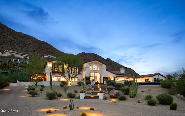 view of front of house featuring curved driveway and a mountain view