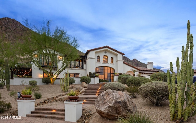 mediterranean / spanish-style house with a balcony, stairway, and stucco siding