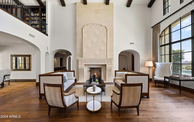 living area featuring a wealth of natural light, beamed ceiling, and wood finished floors