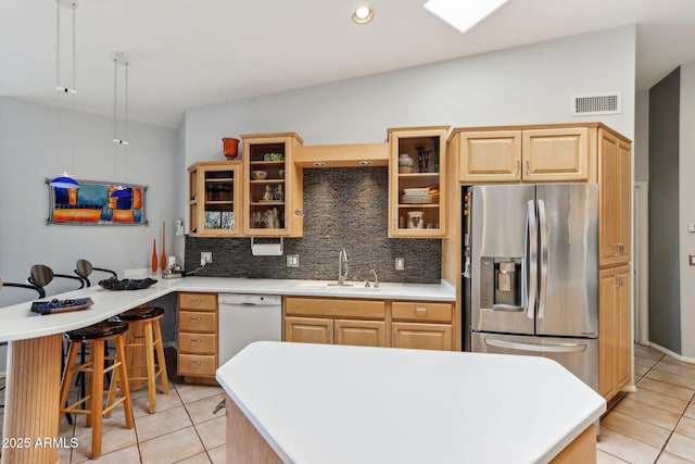 kitchen with visible vents, stainless steel fridge with ice dispenser, white dishwasher, light brown cabinetry, and a sink