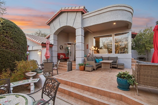 exterior space with a tile roof, outdoor lounge area, a patio, and stucco siding