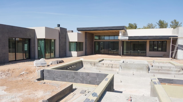 back of property featuring stucco siding
