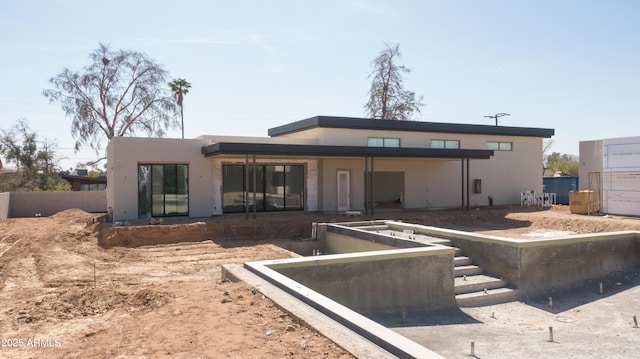 back of property featuring stucco siding